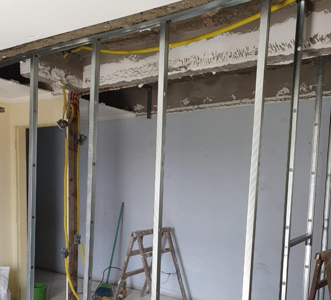 Estrutura metálica de drywall montada, com instalações aparentes no teto