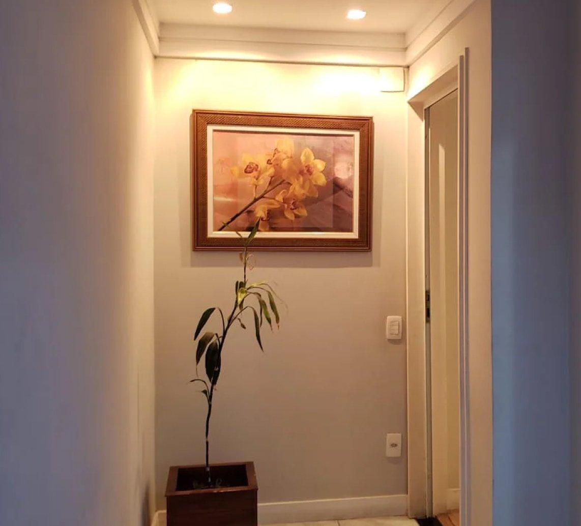 Hall com quadro iluminado e porta de madeira