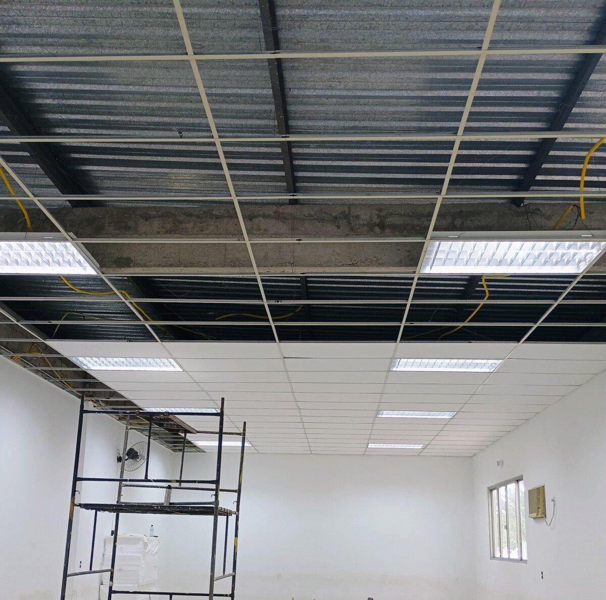 Forro modular e luminárias em montagem, com andaime