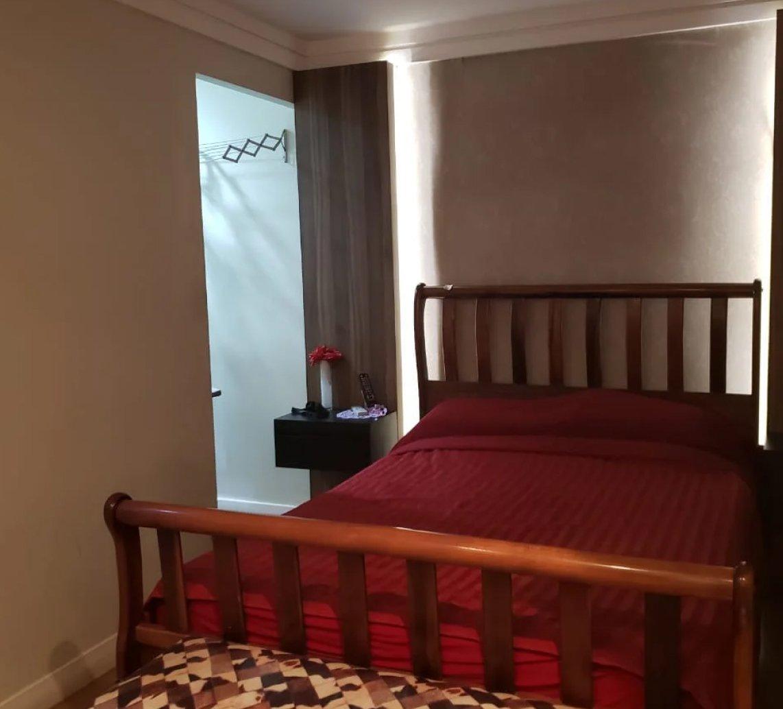 Quarto pronto com painel de madeira e cama de casal