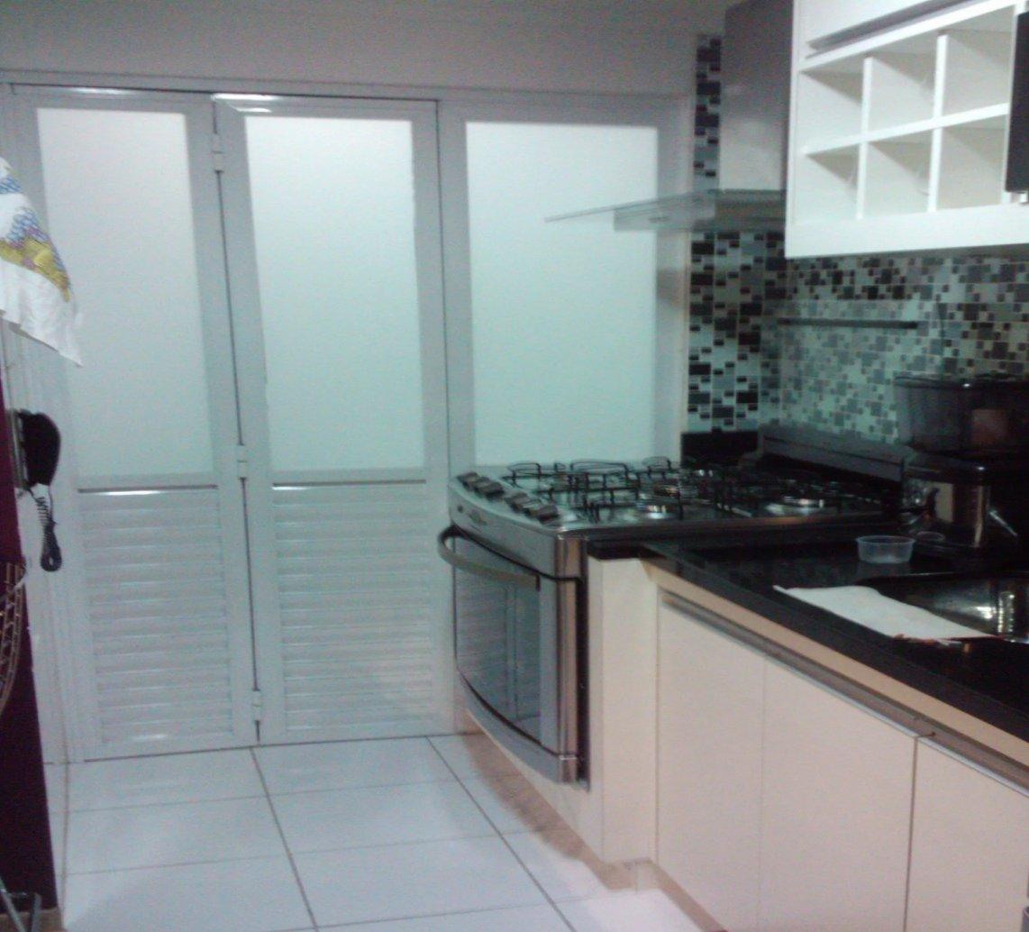 Cozinha pronta com fogão de aço e porta de correr