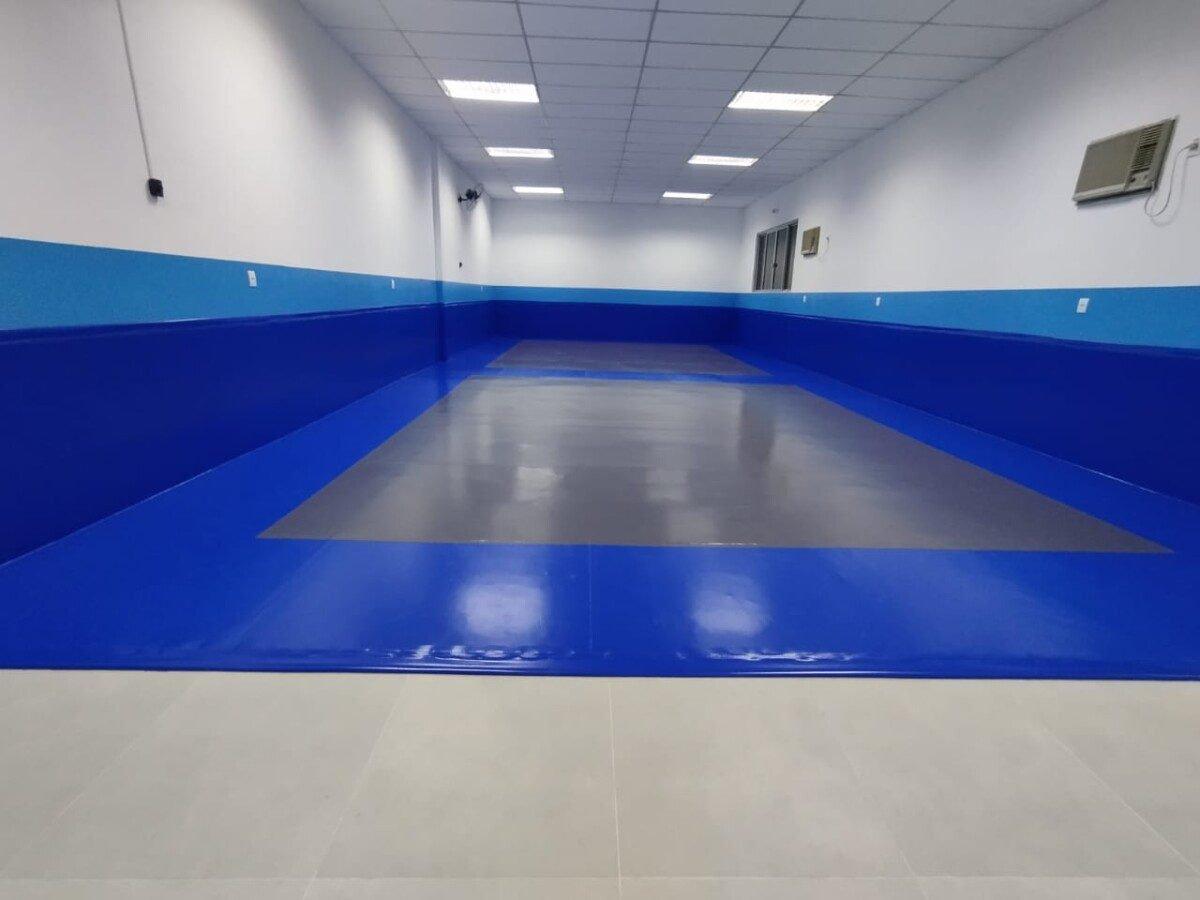 Depois: Sala pronta com tatame azul e piso cinza no centro
