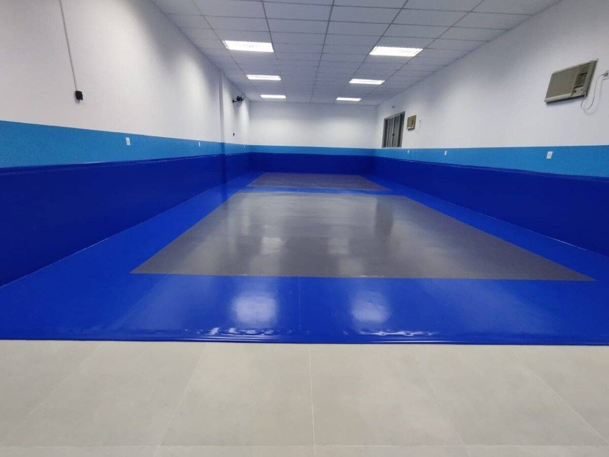 Depois: Sala pronta com tatame azul e piso cinza no centro