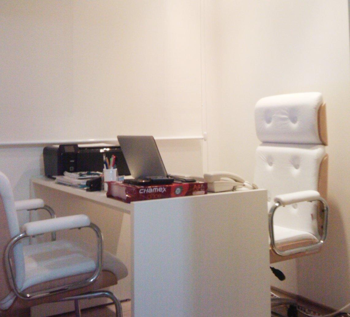 Escritório com mesa branca e cadeira estofada