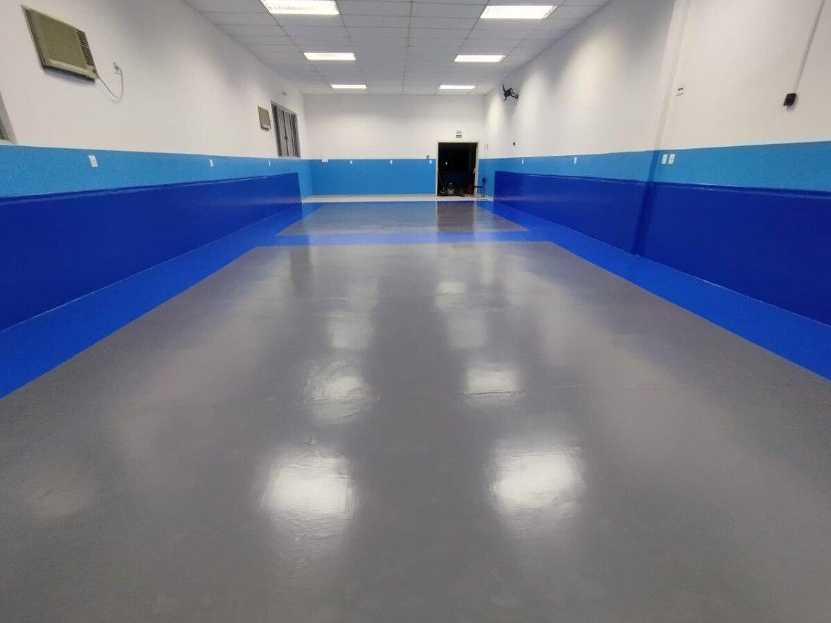 Sala pronta com piso cinza e barra azul nas paredes