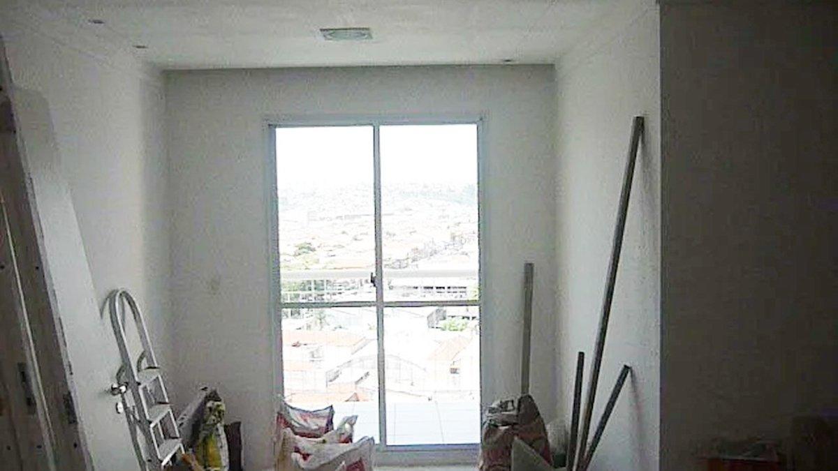 Antes: Sala do apartamento em obra, com materiais e escada no piso