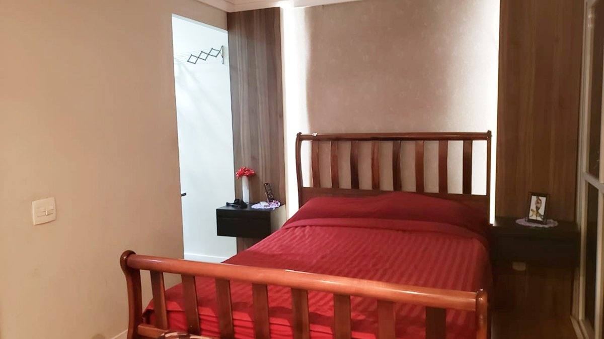 Depois: Quarto pronto com cama de madeira e colcha vermelha