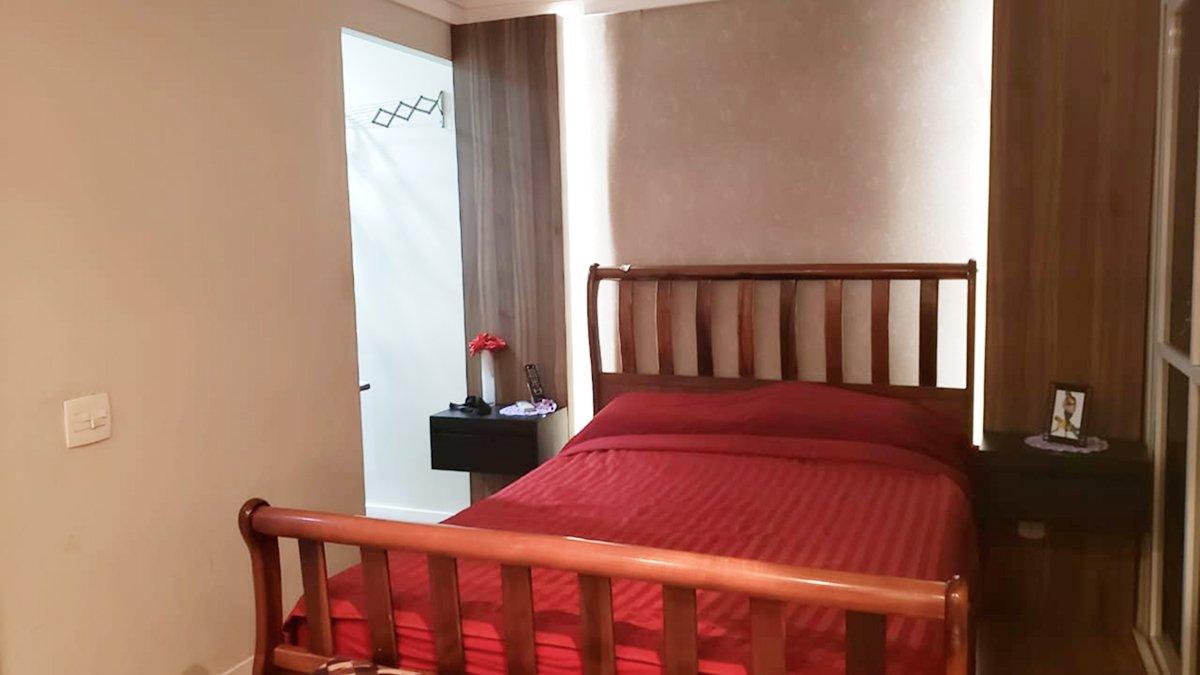 Depois: Quarto pronto com cama de madeira e colcha vermelha