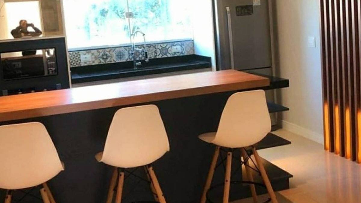 Depois: Cozinha pronta com bancada de madeira e banquetas brancas